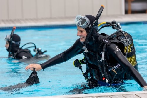 Happy scuba diver training in pool